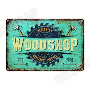 Könnte beinhalten: Rechteckiges Metallschild im Vintage-Look mit Gebrauchsspuren. Das Schild zeigt die Worte "WOODSHOP" in großen, gelben, gepunkteten Buchstaben, mit "Benjamin's Carpentry Services" darüber und "EST. 2020" darunter. Türkisfarbener Hintergrund und rostiger Rand.