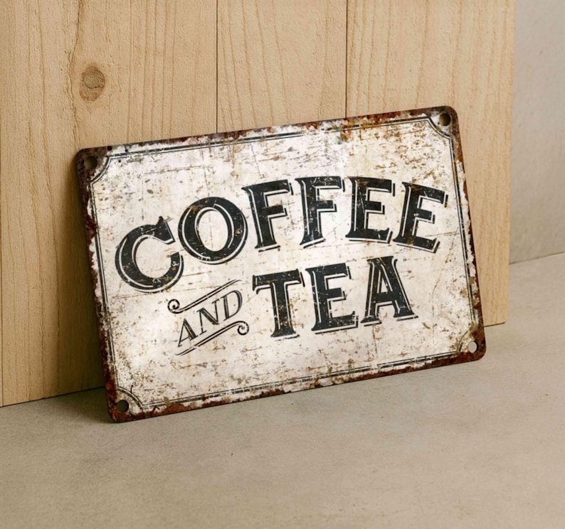 Vintage-style metal sign reading 'COFFEE AND TEA' with distressed white background and rusted edges