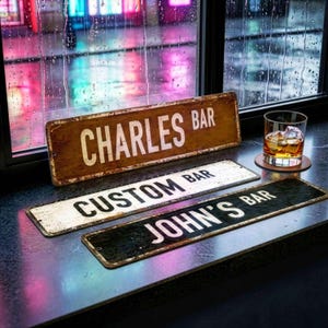 Peut inclure: Trois enseignes de bar rectangulaires en métal avec des finitions vieillies. La première enseigne indique "CHARLES BAR" en lettres blanches sur fond marron. La deuxième est blanche avec "CUSTOM BAR". La troisième est noire avec "JOHN'S BAR".