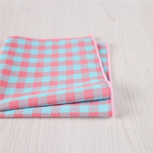 May include: A folded pink and blue checkered pocket square with a pink border.