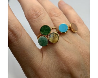 May include: Four gold rings with different colored stones. The stones are green, turquoise, brown, and yellow.