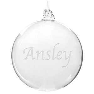 May include: Clear glass ornament with the name "Ansley" etched on the front.
