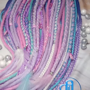 May include: A set of colorful synthetic dreadlocks in shades of pink, purple, blue, and white. The dreadlocks are decorated with beads and feathers.