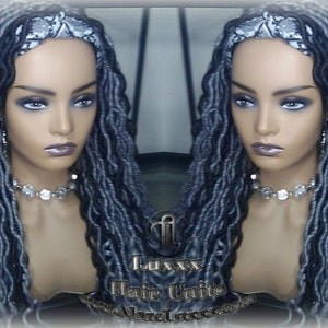 May include: A long, gray and black wig with loose, wavy dreadlocks. The wig is styled with a gray and white patterned headband. The wig is on a mannequin head.