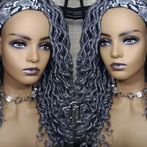 May include: Two mannequin heads with long, gray, curly synthetic hair. Each head is wearing a black and white patterned headband.