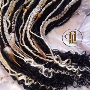 May include: Black and white curly synthetic dreadlocks with brown and gold beads, white feathers, and a white crocheted string.