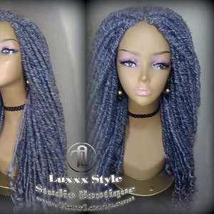 May include: A gray synthetic dreadlock wig on a mannequin head. The wig is long and falls to the shoulders. The wig is styled in a loose, wavy pattern.