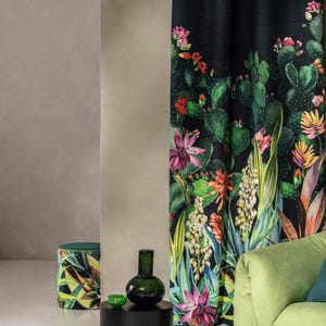 Peut inclure: Un canapé vert avec un rideau à motifs floraux noir et vert derrière. Une table d'appoint noire avec un vase en verre vert et un petit bol vert sur le dessus. Un pouf à motifs vert et noir se trouve au premier plan.