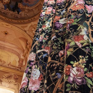 Könnte beinhalten: Schwarzer Stoff mit einem floralen Muster mit rosa, roten und gelben Blumen. Der Stoff hat einen goldenen Metallic-Faden, der in das Design eingewebt ist.