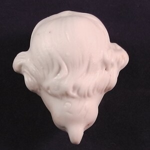 May include: White porcelain doll head with detailed hair sculpted in a side part style.
