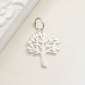 Pu&ograve; includere: Un ciondolo in argento a forma di albero della vita. Il ciondolo &egrave; un design delicato a taglio con un tronco d'albero e rami dettagliati.