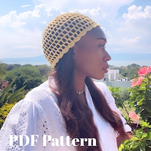 Puede incluir: Un sombrero de ganchillo de color beige claro con un diseño de tejido abierto. El sombrero se lleva en la cabeza. La imagen también muestra una parte superior blanca y el texto "PDF Pattern". El fondo incluye una vista de un lago y el cielo.