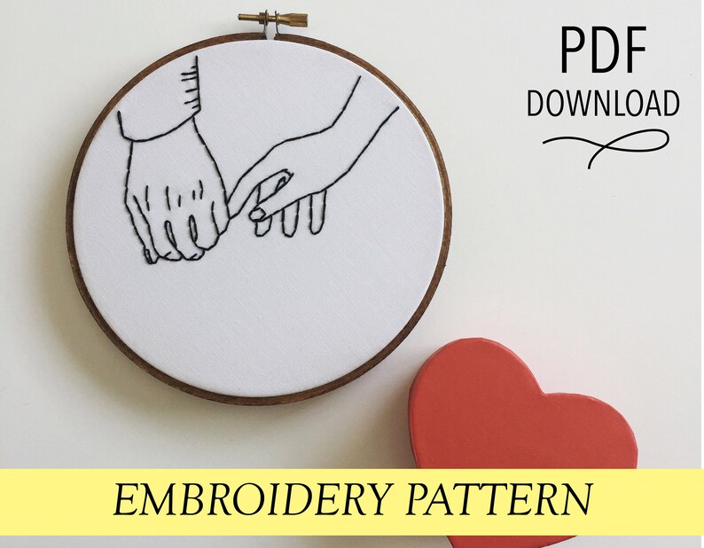 May include: Embroidery pattern featuring two hands holding pinky fingers, stitched in black thread on white fabric, set in a wooden hoop. The text "PDF DOWNLOAD" and "EMBROIDERY PATTERN" are also visible. A red heart-shaped object is in the image.