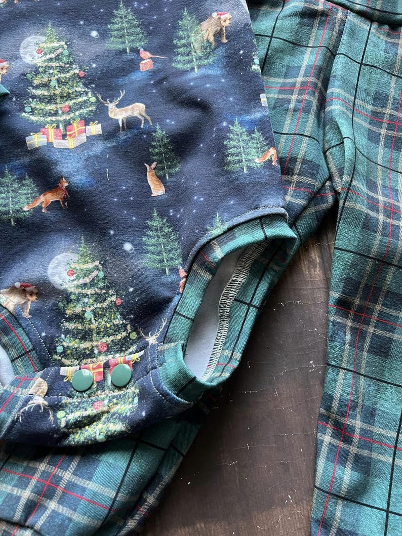 Op de afbeelding: Een blauwe en groene geruite stof met een kerstthema. De print heeft een donkerblauwe achtergrond met een witte maan, sterren en een verscheidenheid aan bosdieren, waaronder herten, vossen en konijnen. De stof heeft ook kerstbomen die versierd zijn met ornamenten en cadeaus. De stof is perfect voor knutselprojecten, zoals kleding, dekens en kussens.