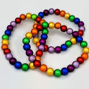 May include: Three bracelets featuring a spectrum of colours: red, orange, yellow, green, blue, and purple. The round beads are arranged in a circular design. Ideal for stacking or wearing separately. Each bracelet is made of round beads.