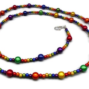 May include: A rainbow beaded necklace with alternating small and large beads. The large beads are iridescent and the small beads are matte.
