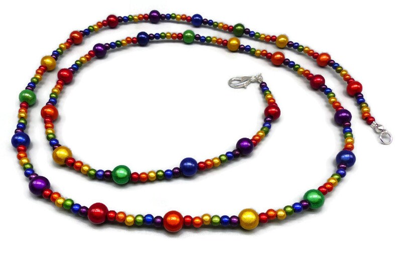 May include: A rainbow beaded necklace with alternating small and large beads. The large beads are iridescent and the small beads are matte.