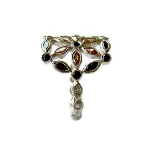Puede incluir: Un anillo de plata con un dise&ntilde;o floral con piedras preciosas negras, marrones y transparentes.