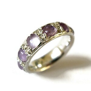 May include: A silver band ring with five purple gemstones set in a floral design.