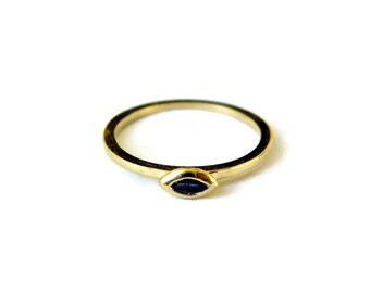 May include: A gold ring with a black eye-shaped stone.