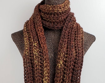 May include: A brown and gold striped crocheted scarf. The scarf is displayed on a brown mannequin.