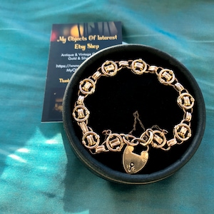 May include: A gold chain bracelet with a heart-shaped padlock clasp. The bracelet is in a black velvet box. The box has a card on top that says "My Objects Of Interest Etsy Shop Antique & Vintage Gold & Silver https://www. My Objects Of Interest Etsy Shop"