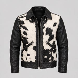 May include: A jacket featuring a black and white cowhide print on the front panels, contrasted with solid black leather sleeves, a black collar, and a black hem. The garment includes a central silver-toned metal zipper and two slanted zippered pockets.