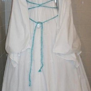 Op de afbeelding: Witte off-the-shoulder jurk met lange, pofmouwen. De jurk heeft een turquoise korset-achtige veterdetail op de rug en een bijpassende stropdas. De stof is zacht en vloeiend, perfect voor een renaissance- of middeleeuws thema.