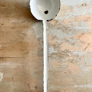 A French ladle, vintage, white enamel, some chips and rust.