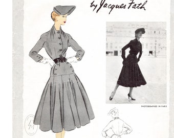 Può includere: Un'illustrazione vintage di una donna che indossa un abito grigio con una cintura nera e un cappello. L'abito ha una gonna ampia e un corpetto aderente. L'illustrazione è tratta da una rivista di moda e include il testo "by Jacques Fath" e "fotografato a Parigi".