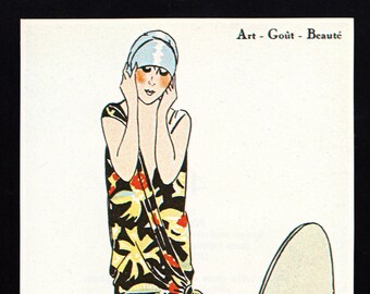 Op de afbeelding: Vintage illustratie van een vrouw in een zwarte jurk met gele, rode en blauwe bloempatronen. Ze draagt een lichtblauwe hoofdband en staat bij een spiegel. De tekst "Art - Goût - Beauté" staat bovenaan.