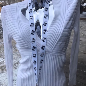 May include: White lanyard with black and white theater masks printed on it. The lanyard is hanging on a white mannequin.