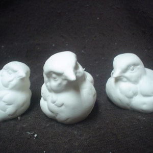 May include: Three white ceramic bird figurines, each with a slightly different pose, are ready to be painted.