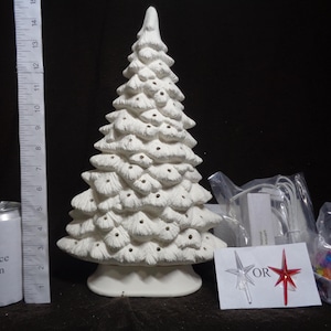 May include: A white ceramic Christmas tree with textured details and pre-drilled holes for lights. The tree is approximately 10 inches tall. Accessories include a star topper, multi-colored light bulbs, and a light kit.