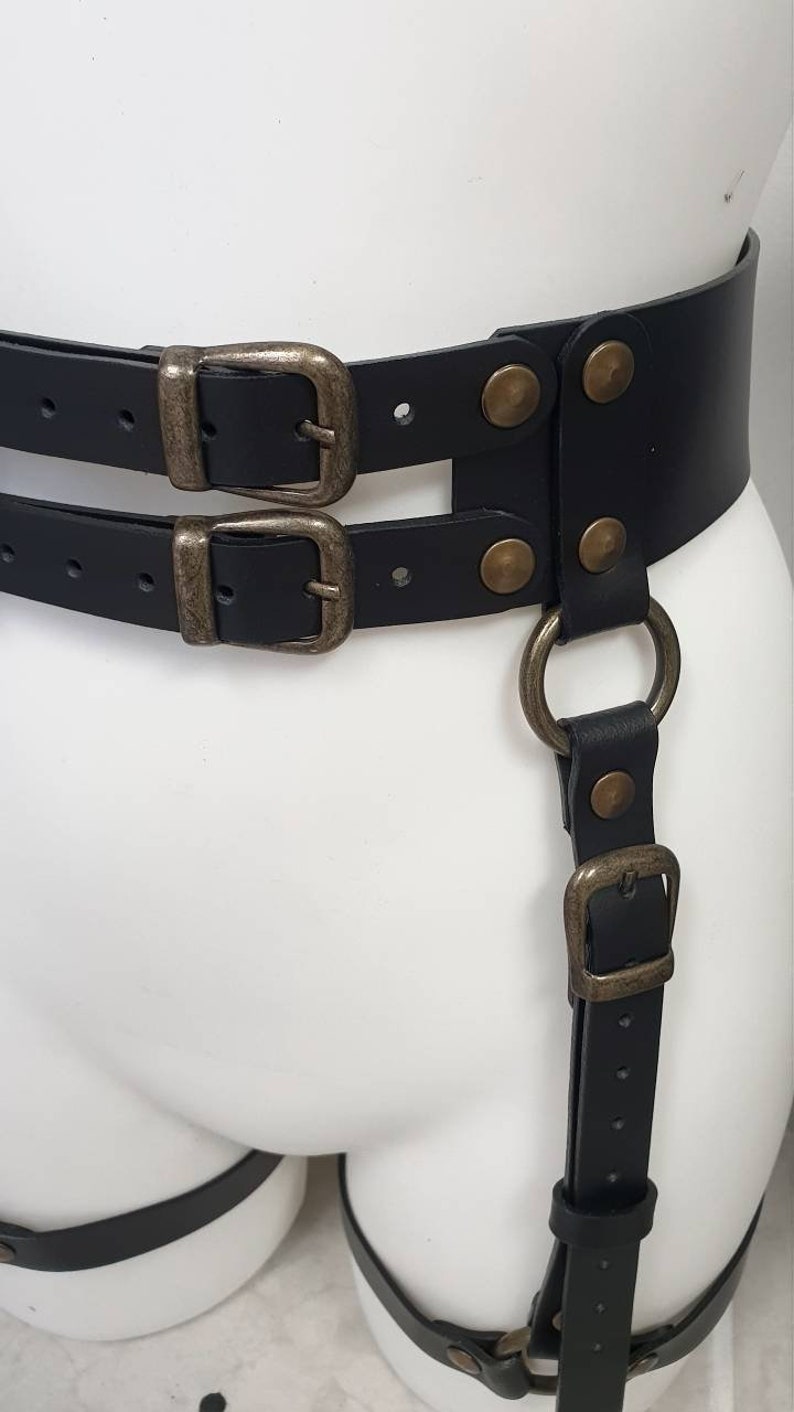 Puede incluir: Arn&eacute;s de cuero negro con dos cinturones, dos hebillas y dos anillas en D. El arn&eacute;s tiene un acabado decorativo de lat&oacute;n antiguo.