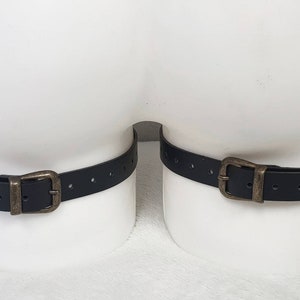 Puede incluir: Dos correas de cuero negro con hebillas de lat&oacute;n. Las correas son ajustables y tienen varios agujeros para diferentes tama&ntilde;os.