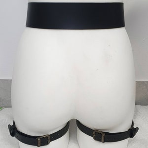 Puede incluir: Cintur&oacute;n de cuero negro con dos correas para las piernas a juego. Las correas tienen hebillas met&aacute;licas.