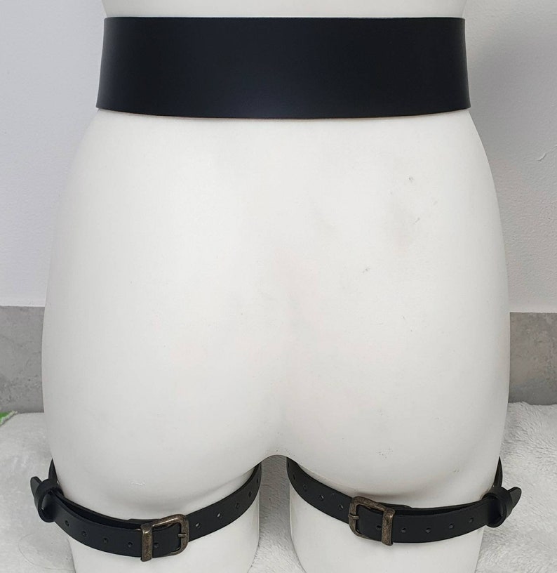 Puede incluir: Cintur&oacute;n de cuero negro con dos correas para las piernas a juego. Las correas tienen hebillas met&aacute;licas.