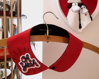 Red polka-dot cotton Peter Pan collar featuring "Oh yeah" patch on one side. With black button on the front.