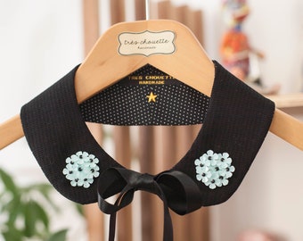 Black weaved cotton Peter Pan collar featuring two turquoise sequined flower patches . With black ribbon as closure