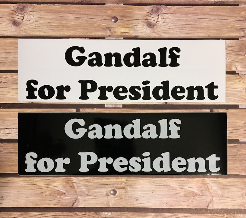 May include: Two black and white signs with the text "Gandalf for President" in a retro font. The top sign has black text on a white background, and the bottom sign has white text on a black background.