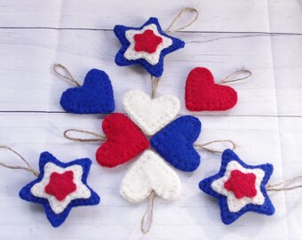 May include: A set of felt ornaments in red, white, and blue, featuring stars and hearts. The ornaments are perfect for decorating for a patriotic holiday.
