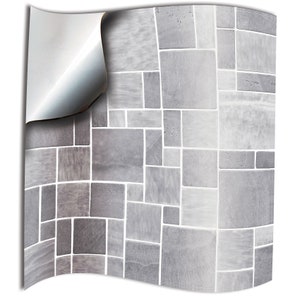 May include: Grey and white self-adhesive tile contact paper. The paper has a mosaic pattern of different sized squares.