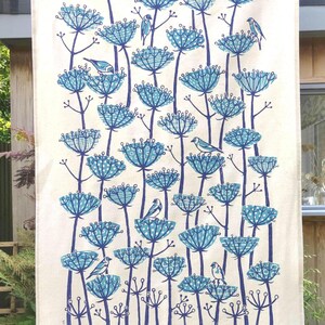 Peut inclure: Une serviette de cuisine blanche avec un motif floral bleu et blanc. Les fleurs sont stylis&eacute;es et pr&eacute;sentent un motif g&eacute;om&eacute;trique. De petits oiseaux bleus sont perch&eacute;s sur les fleurs. Le texte "Alison  Hally  Art" est imprim&eacute; dans le coin inf&eacute;rieur droit.