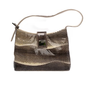 May include: A small, shoulder bag with a snakeskin pattern in shades of brown, beige, and cream. The bag has a curved shape, a single handle, and a rectangular clasp with the text "MANILA MAULI".