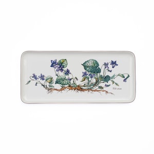 May include: A rectangular white ceramic serving tray featuring a detailed botanical illustration of purple violet flowers with green leaves and brown roots. The text Viola odorata is printed in small black script near the right side of the tray.