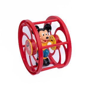 May include: A red plastic toy with a Mickey Mouse figure inside. The toy has a wheel on each end and a cage-like structure around the figure.