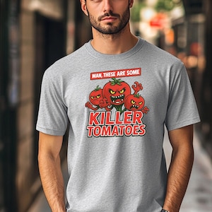May include: A gray t-shirt with a cartoon image of three red tomatoes with angry faces. The text "Man, these are some Killer Tomatoes" is printed on the shirt.