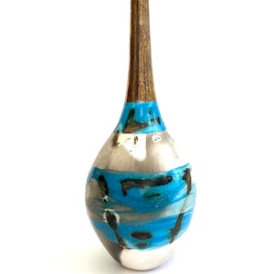Könnte beinhalten: Eine Keramikvase mit einem langen, dünnen Hals und einem runden Körper. Die Vase ist mit einer blauen, weißen und schwarzen Glasur verziert.