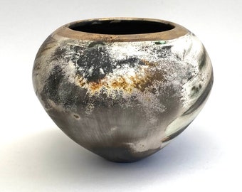 A smoke-fired ceramic pot.